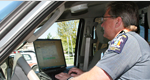 Officer in car with computer